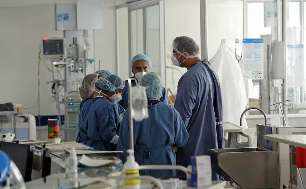 Personal de salud en un hospital peruano durante una reunión de equipo médico en un entorno clínico. Equipo médico en acción en una clínica moderna en Loreto, Perú, atendiendo a pacientes en un ambiente de alta tecnología.