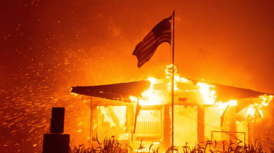 Incendio destruyendo una casa en Loreto Noticias, con bandera de Estados Unidos en el centro, ambiente de caos y emergencia en noticias locales de Loreto Perú.