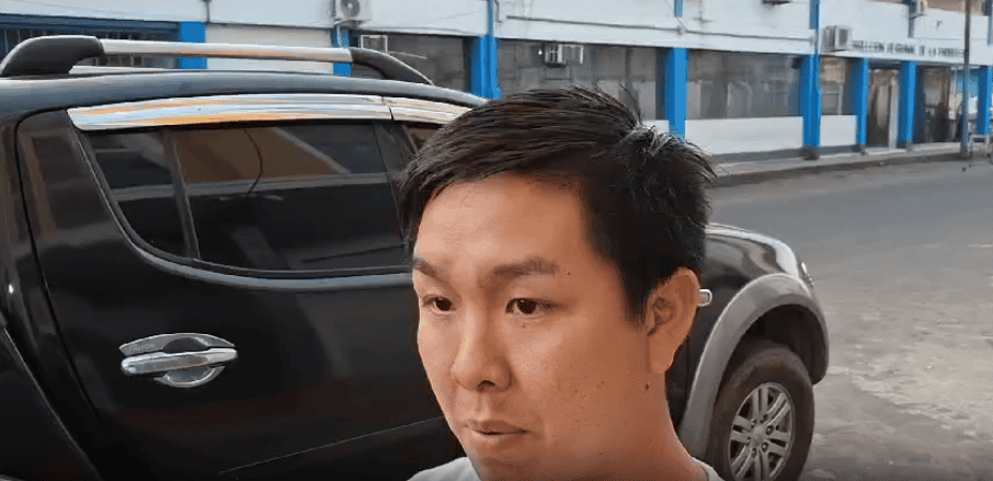 Auto negro estacionado en calle de Loreto Noticias con joven hombre en primer plano.