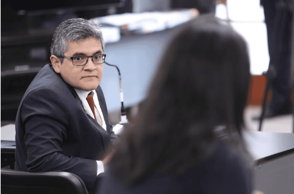 Neoyorkino hombre con gafas en una reunión formal en un entorno de oficina, participando en una discusión importante, representante de noticias y actualidad en Loreto Noticias.