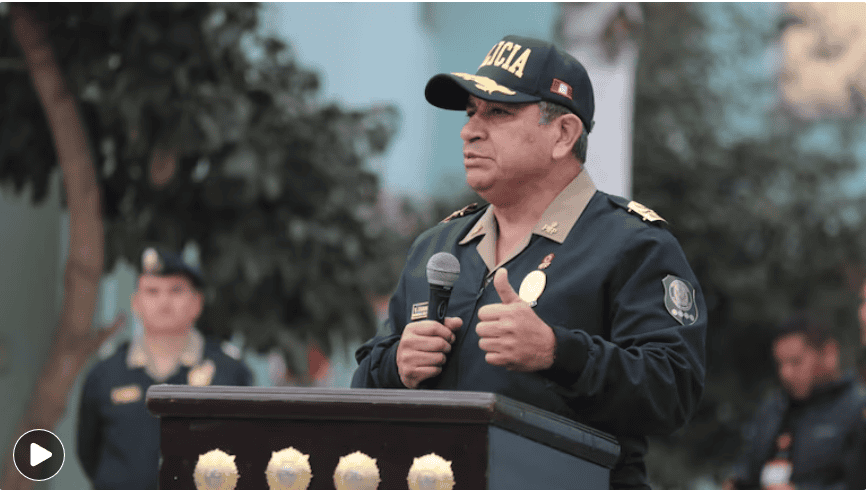 Policía dando un discurso en evento público en Loreto, Perú, con uniforme oficial y micrófono, en un entorno al aire libre.