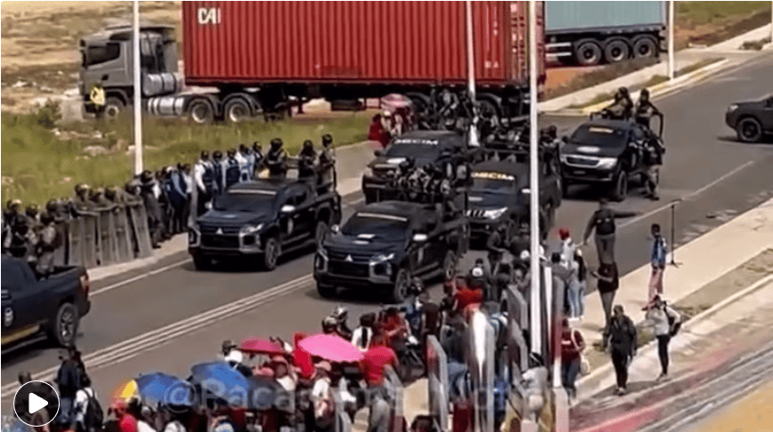 Protesta en Loreto Noticias, concentración de personas y vehículos en la vía pública en Loreto, Perú, con presencia policial y manifestantes con paraguas, en contexto de movilización social.