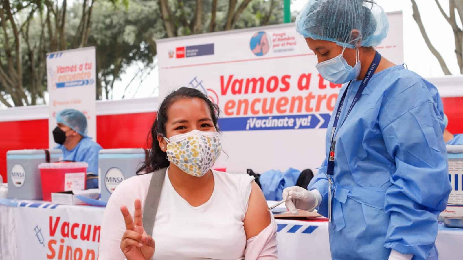 Vacunación contra el COVID-19 en Loreto, Perú, campaña de vacunación en exteriores, personal de salud administrando vacuna a mujer con cubrebocas, campaña de inmunización masiva, Loreto Noticias.