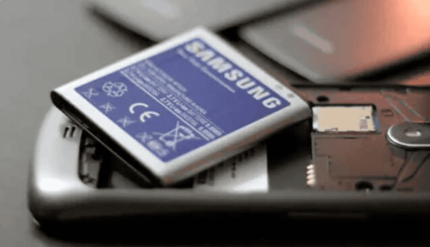 Batería de repuesto para teléfono móvil sobre una superficie gris, con enfoque en componentes tecnológicos y reparación de dispositivos electrónicos.