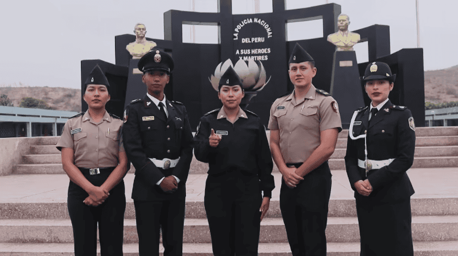 Policías femeninas y masculinos en ceremonia cívica en Loreto, Perú, destacando el compromiso de las fuerzas del orden en la región, con monumentos alusivos a la policía nacional y héroes nacionales.