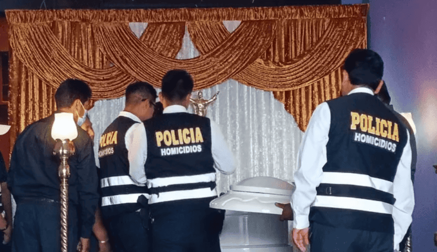 Acción policial en una sala de velorio durante un homenaje en Loreto, Perú, destacando la presencia de oficiales de Homicidios en una investigación criminal.