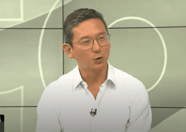 Socio mostrando conversación en programa de noticias de Loreto Noticias con fondo de pantalla moderno y profesional.