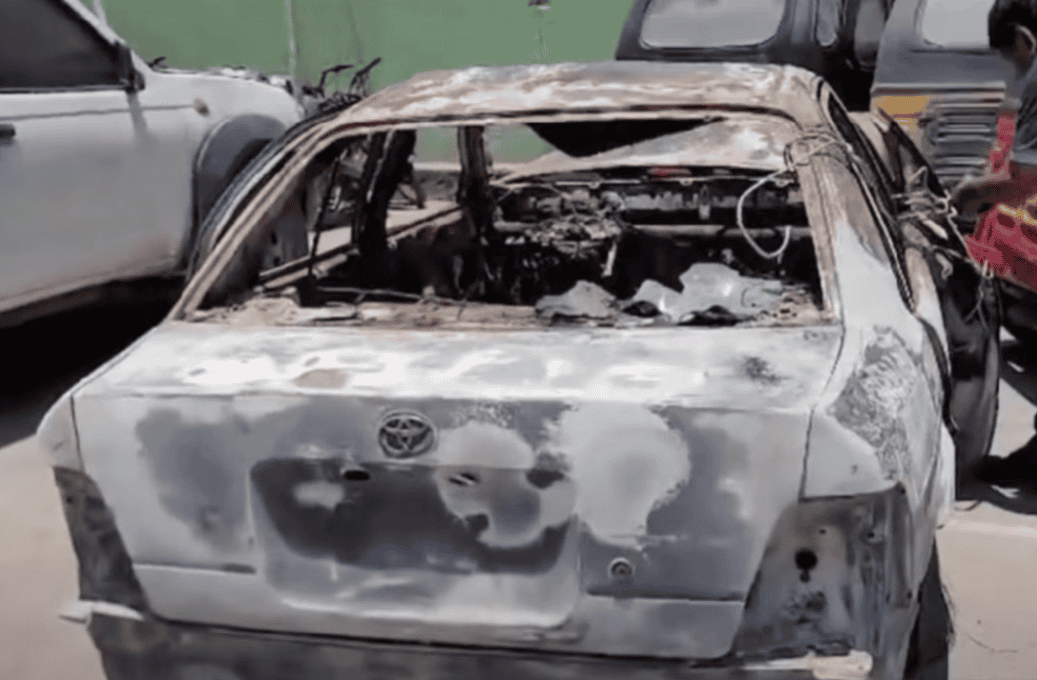 Automóvil incendiado y quemado tras un accidente en Loreto, Perú. Policía y testigos en el lugar evalúan los daños y las causas del siniestro en la zona.