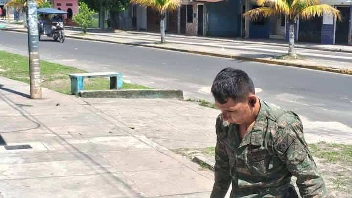 Soldado del ejército peruano en uniforme militar en la calle de Loreto, Perú, trabajando en tareas de seguridad o apoyo community. La imagen refleja la presencia de las fuerzas armadas en labores de mantenimiento y protección ciudadana en Loreto, Perú.