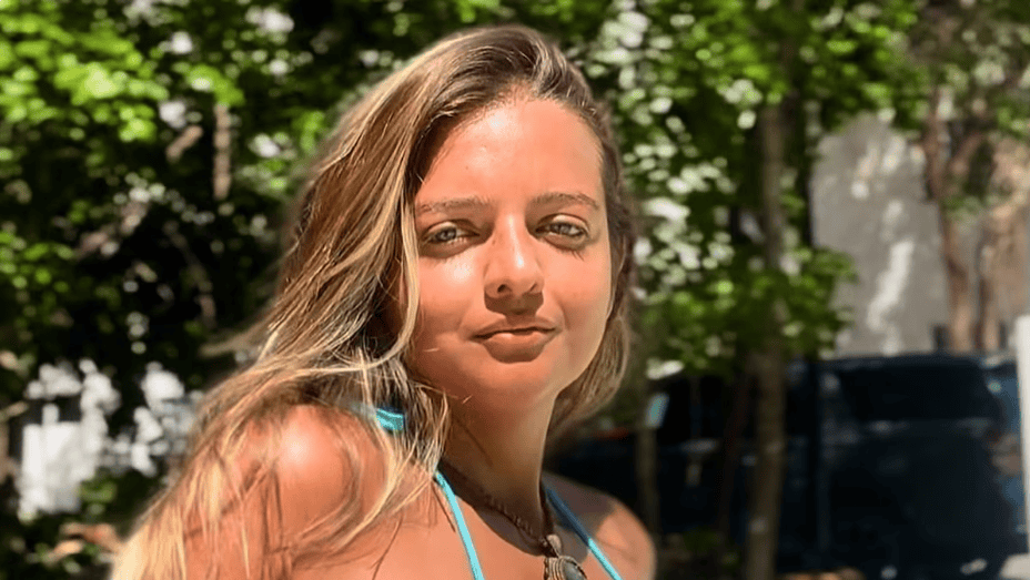 Hermosa joven con cabello largo y rubio en un entorno natural con árboles y clima soleado, en Loreto Noticias, Perú.