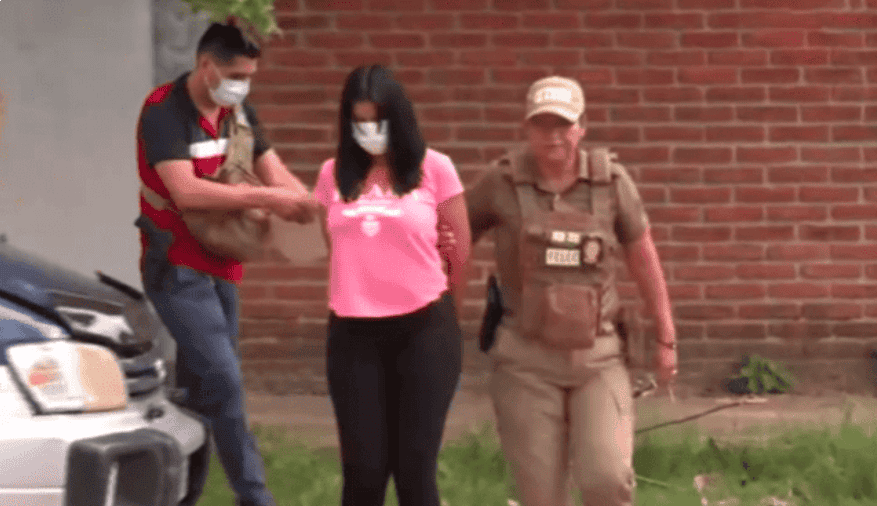 Detención de una mujer sospechosa en Loreto, Perú, por presunta participación en actividades ilícitas, acompañada por agentes de la policía en operación policial en una zona urbana.