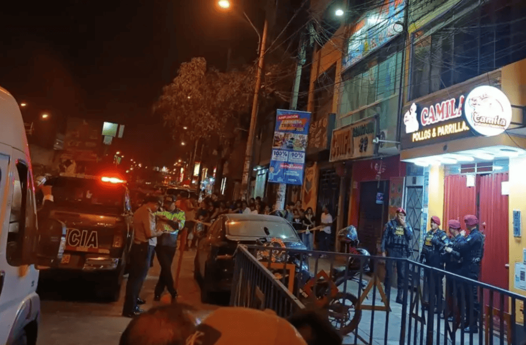 Policías y vecinos en la calle de Loreto durante una noche con movimiento, en medio de un incidente con presencia policial y varios espectadores en el fondo.