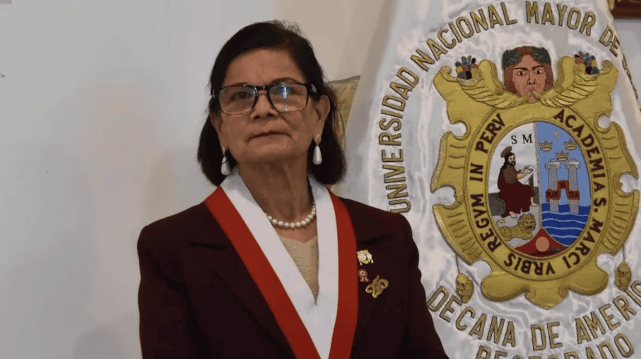 Licenciada en Derecho con medalla y collar, en ceremonia oficial de Loreto Noticias, en la Universidad Nacional Mayor de San Marcos, con bandera y escudo institucional visibles.