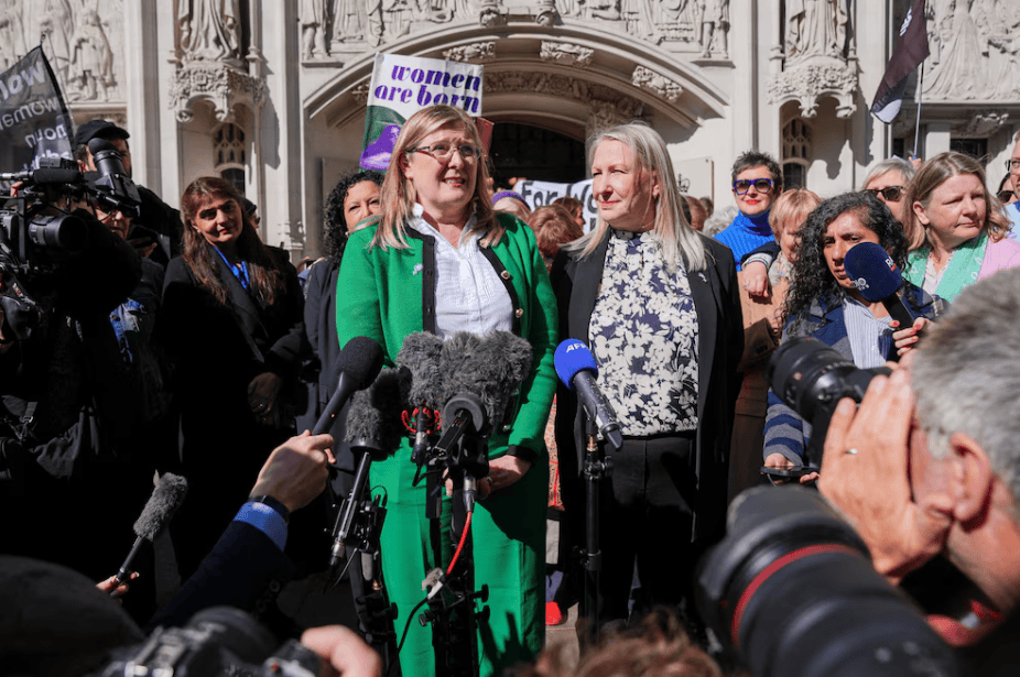 Manifestantes feministas en una protesta frente a un edificio histórico, con varias mujeres y periodistas en el lugar, promoviendo derechos de las mujeres y igualdad de género en Loreto Noticias.