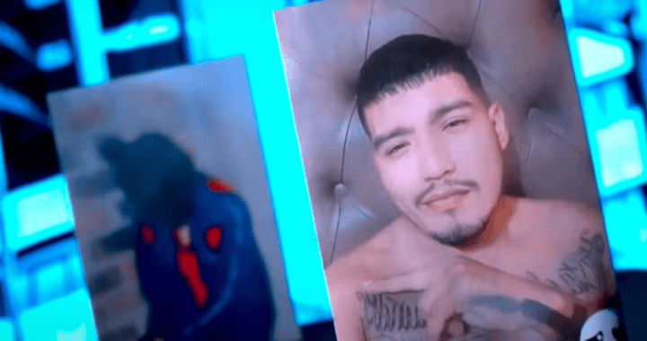 Hombre con tatuajes en el pecho y rostro relajado, en un entorno con iluminación azul y pantallas digitales, en un contexto posiblemente de medios o noticias en Loreto.