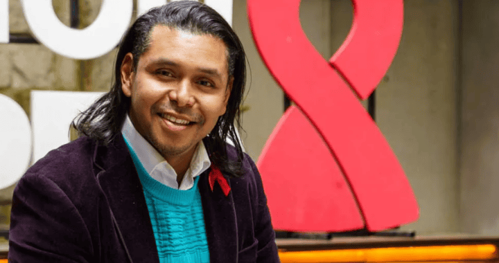 Joven sonriente en evento comunitario en Loreto, Perú, con símbolo de lucha contra el VIH.