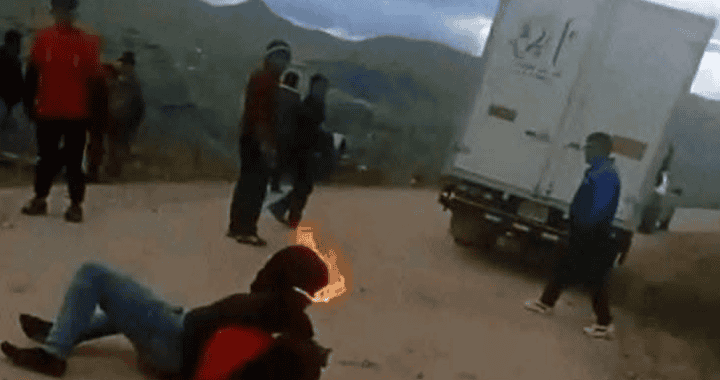 Camion en la carretera con personas observando, joven en el suelo y cielo nublado, imagen de noticias locales en Loreto, Perú.