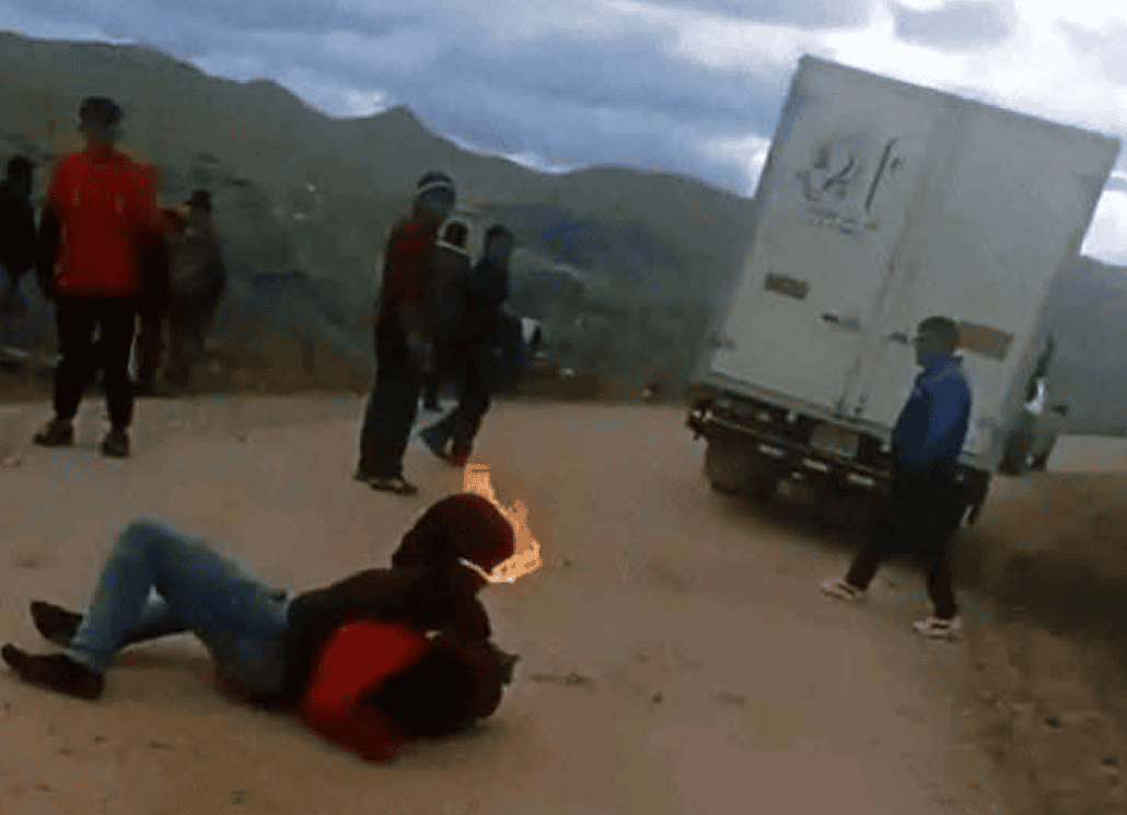 Camion en la carretera con personas observando, joven en el suelo y cielo nublado, imagen de noticias locales en Loreto, Perú.