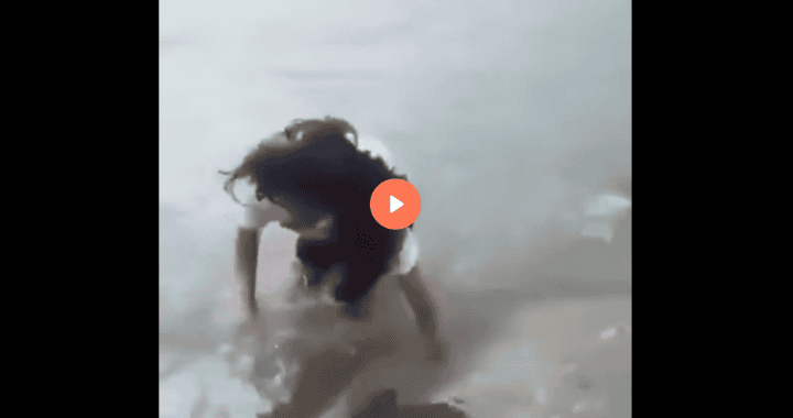 Nina jugando en la playa de Loreto, Perú, con agua y arena, disfrutando de un día soleado en la costa peruana.