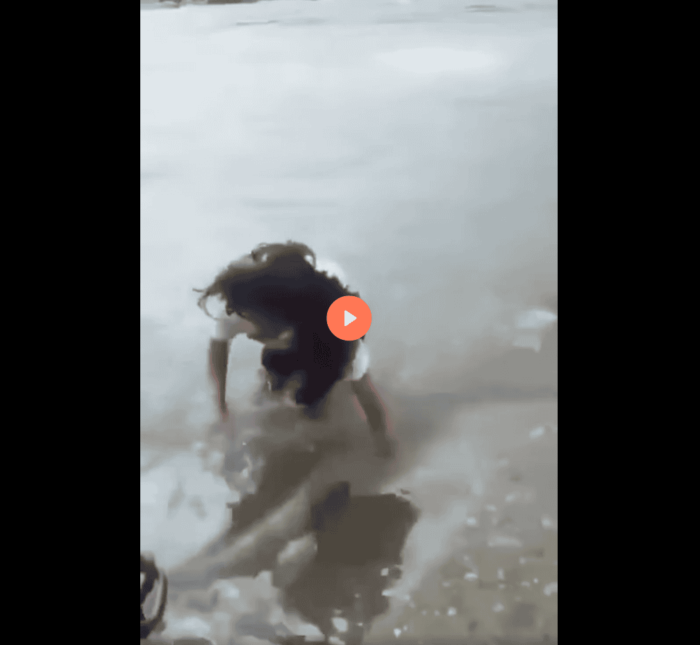 Nina jugando en la playa de Loreto, Perú, con agua y arena, disfrutando de un día soleado en la costa peruana.