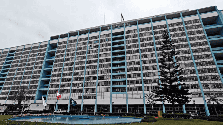 Edificio corporativo en Loreto Noticias con fachada moderna y árboles en la entrada en Loreto, Perú.