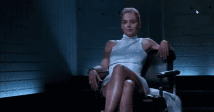 Mujer en silla de oficina en una escena cinematográfica, vestida con un vestido blanco, en un ambiente oscuro y moderno, proyectando confianza y estilo en un entorno de drama.