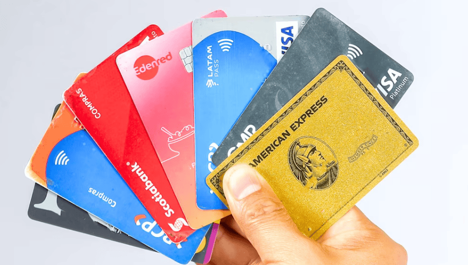 Tarjetas de crédito y débito de diferentes bancos y marcas, incluyendo Visa, Mastercard, y American Express, en manos de una persona, representando servicios financieros y pagos digitales en Loreto Noticias.