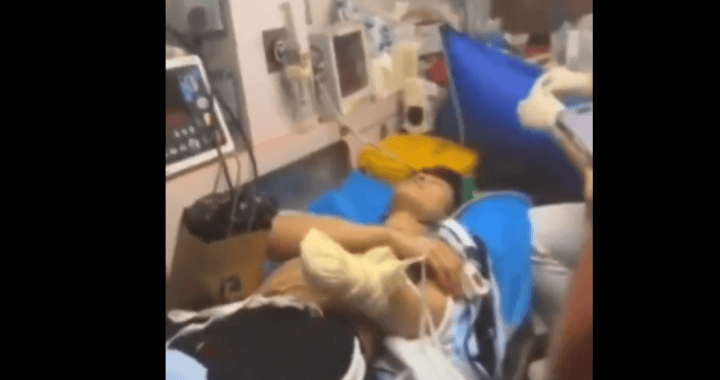 Paciente en cama en hospital, rodeado de equipos médicos y monitores de salud, en proceso de recuperación en un centro hospitalario en Loreto, Perú.