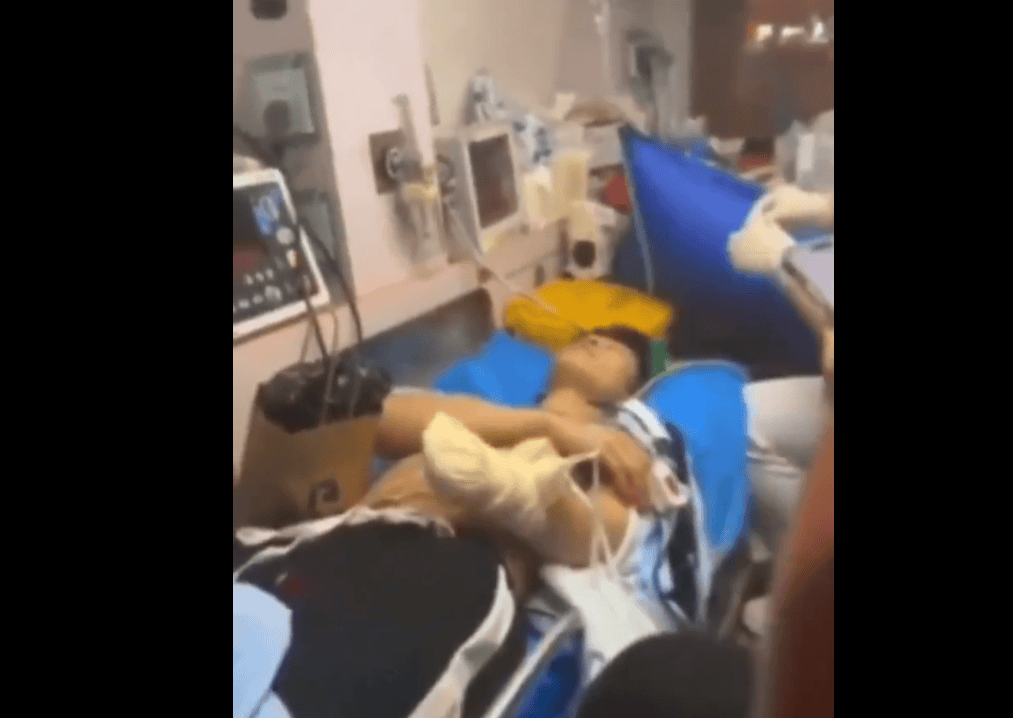 Paciente en cama en hospital, rodeado de equipos médicos y monitores de salud, en proceso de recuperación en un centro hospitalario en Loreto, Perú.