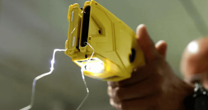 Arma de descarga eléctrica en mano, simulando un dispositivo electrizante para captura o asalto. Imagen que transmite tensión y peligro en escenarios de seguridad y vigilancia.