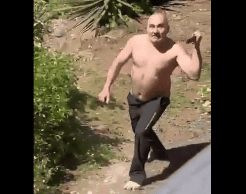 Persona corriendo sin camisa en un área de vegetación en Loreto, Perú, apariencia relajada y gesto sonriente, ambiente exterior natural y soleado.