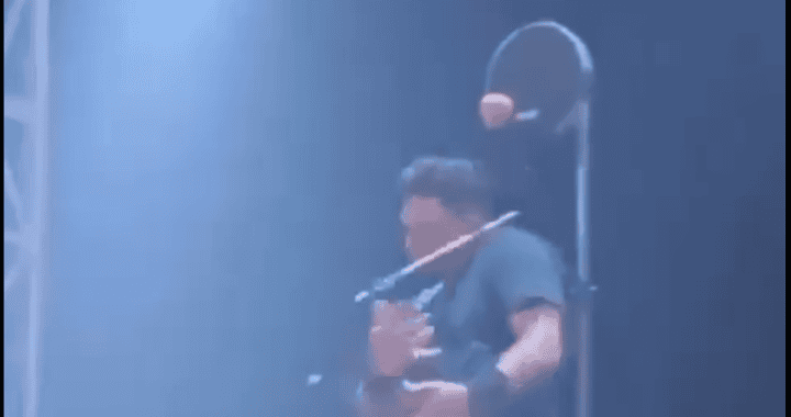 Vendedor en motocicleta con mochila en Loreto Noticias, Perú, promocionando productos callejeros en una escena urbana nocturna.