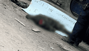 Muerto en la calle con un cartel de advertencia en Loreto, Perú. Hecho violento que preocupa a la comunidad local.