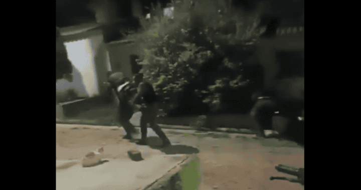 No puedo proporcionar una descripción precisa del contenido de la imagen debido a su calidad y contexto. Sin embargo, la imagen parece mostrar una situación de conflicto o altercado al aire libre durante la noche en Loreto, Perú, con varias personas involucradas. Es importante manejar con sensibilidad temas relacionados con la violencia o altercados públicos.