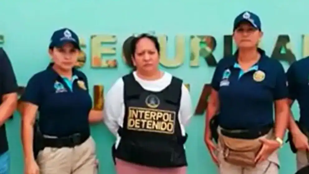 Detenida de INTERPOL en Loreto, Perú, en operación contra crimen organizado, acompañada de agentes policiales, en evento de seguridad y lucha contra delitos en la región.