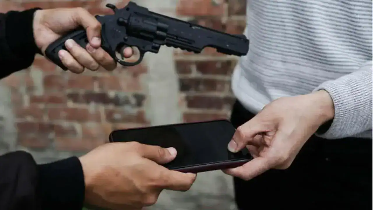 Armas de fuego y celular en una escena de investigación policial en Loreto, Perú. La imagen muestra a una persona entregando un arma a otra, en un contexto de manejo de delitos.