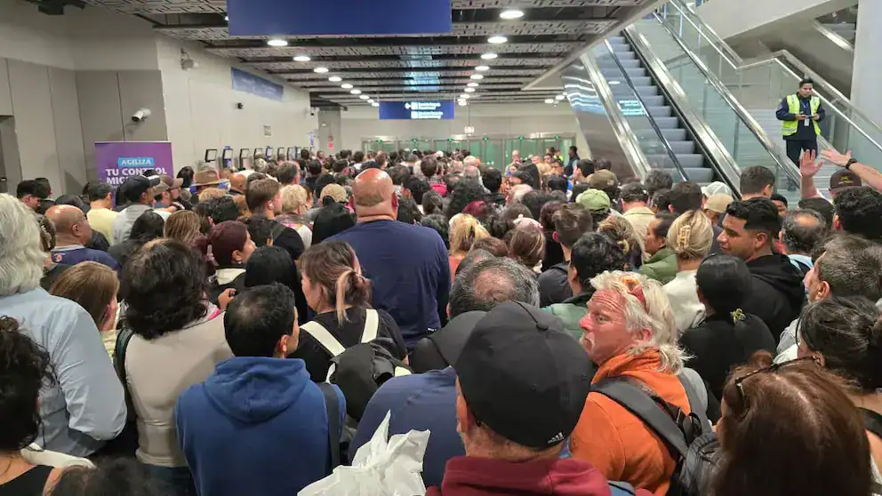 Multitud de personas en aeropuerto de Loreto, esperando en fila para embarque, en un ambiente de gran afluencia y movimiento.