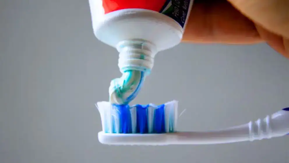 Bote de pasta dental siendo aplicado en un cepillo de dientes, higiene bucal, cuidado dental, prevención de caries, salud oral, Loreto Noticias.