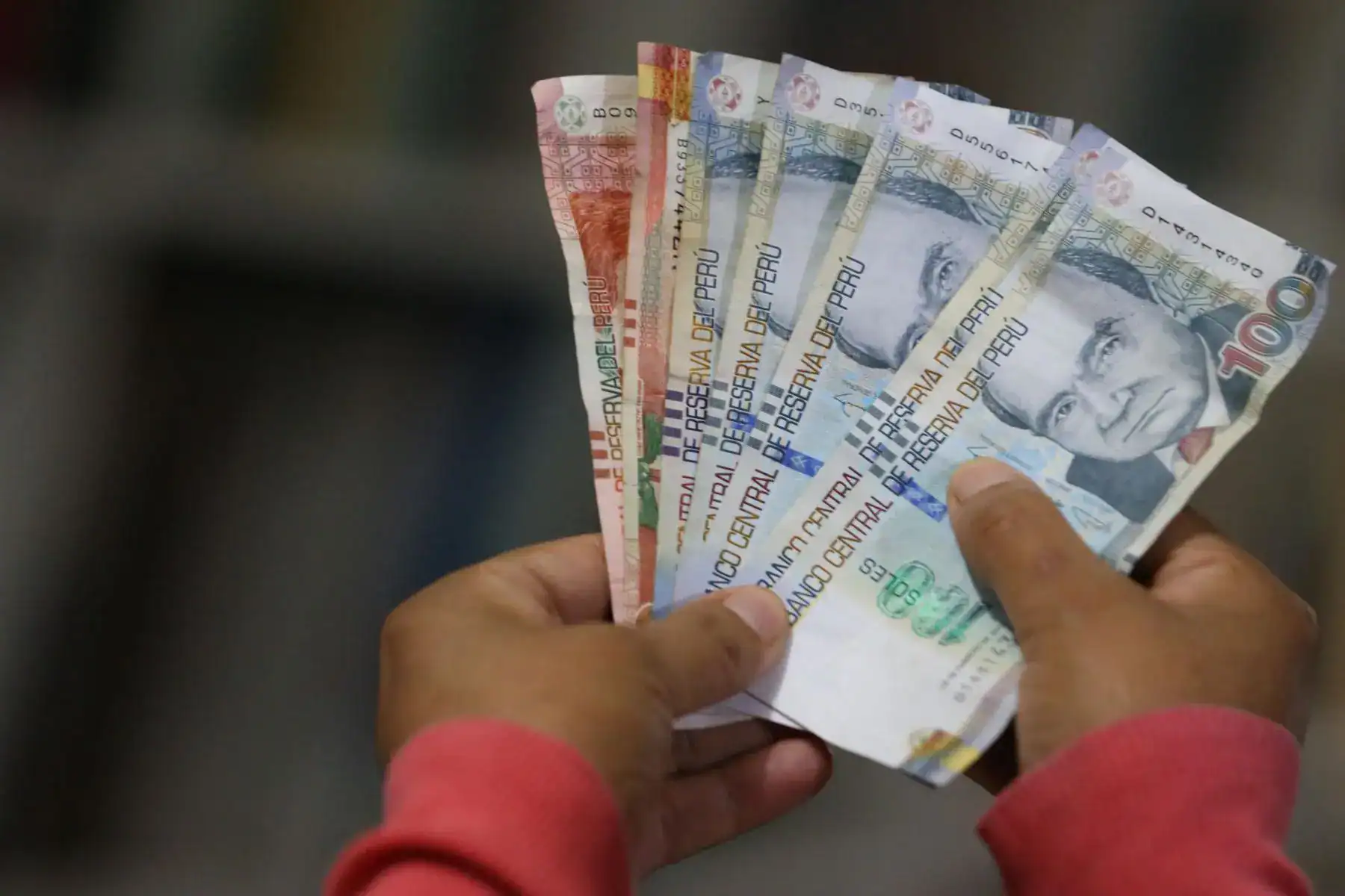 BIlletes de sol peruanas de 10 soles en manos, dinero en efectivo, economía peruana, dinero en Perú, billetes nuevos, finanzas, economía local, moneda peruana, billetes en circulación, valores monetarios.