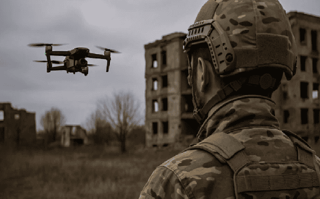Soldado con equipo militar observa un dron en un entorno de guerra en zonas urbanas en Loreto Noticias.