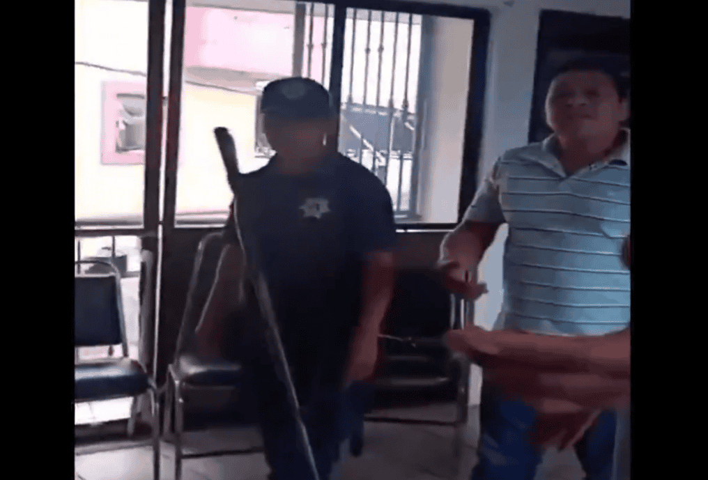 Policía arresta a un hombre en un local público, en Loreto, Perú. Imagen muestra intervención policial en una oficina o sala de espera con muebles y ventanas de barrotes.