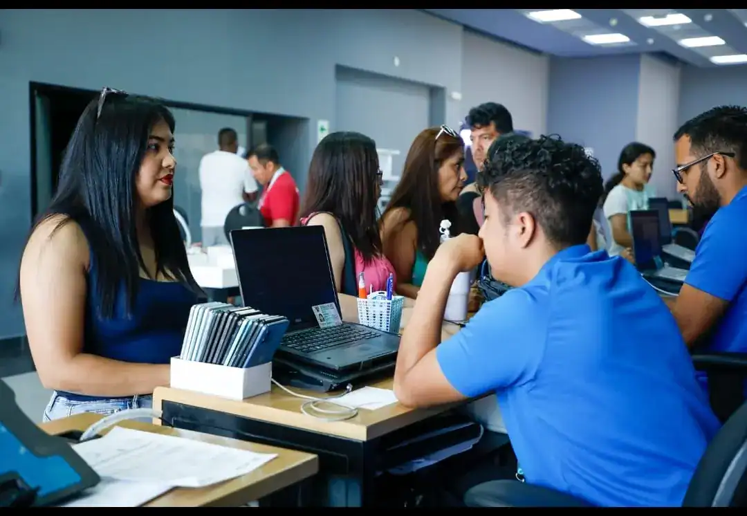 Personas atendiendo en un mostrador de atención al cliente en evento o feria en Loreto Peru.