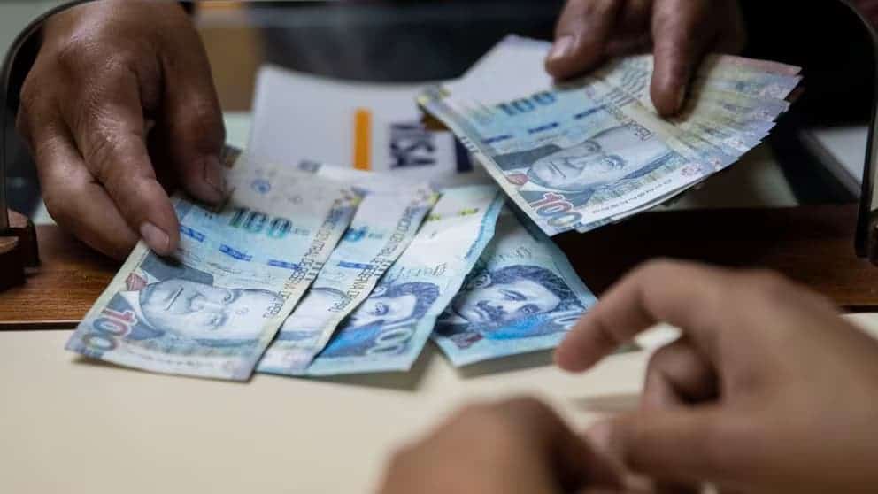 Billetes de dinero en efectivo de nuevos soles peruanos en una transacción financiera.