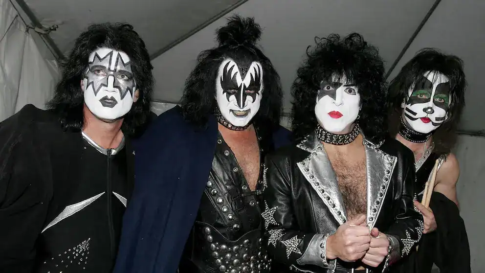 Rock en vivo banda musical estilo glam metal en concierto, maquillaje teatral y vestuarios llamativos en escenario de Loreto Noticias.