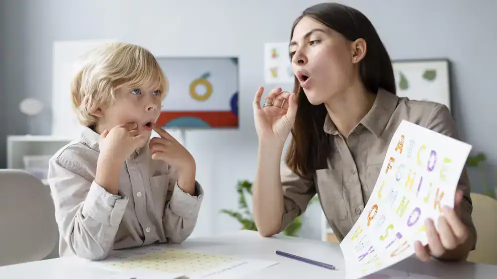 De niño y maestra en terapia del habla,listos para aprender y mejorar habilidades de comunicación.