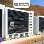 Universidad Continental campus en Loreto, Perú, edificio moderno con fachada de vidrio y logo visible, en un entorno natural de colinas y áreas verdes, ejemplo de innovación educativa en la región.