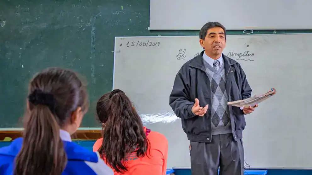 Maestro enseñando en aula escolar en Loreto, Perú, durante una clase de educación. Profesor explicando conceptos a estudiantes en un entorno educativo tradicional en Loreto Noticias.