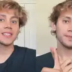 Atractivo hombre joven con cabello rizado y expresión amigable en un fondo neutro.