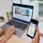 Acceso digital a Loreto Noticias mediante laptop y smartphone en una oficina moderna. Herramientas tecnológicas para mantenerse informado en tiempo real sobre noticias del Perú.