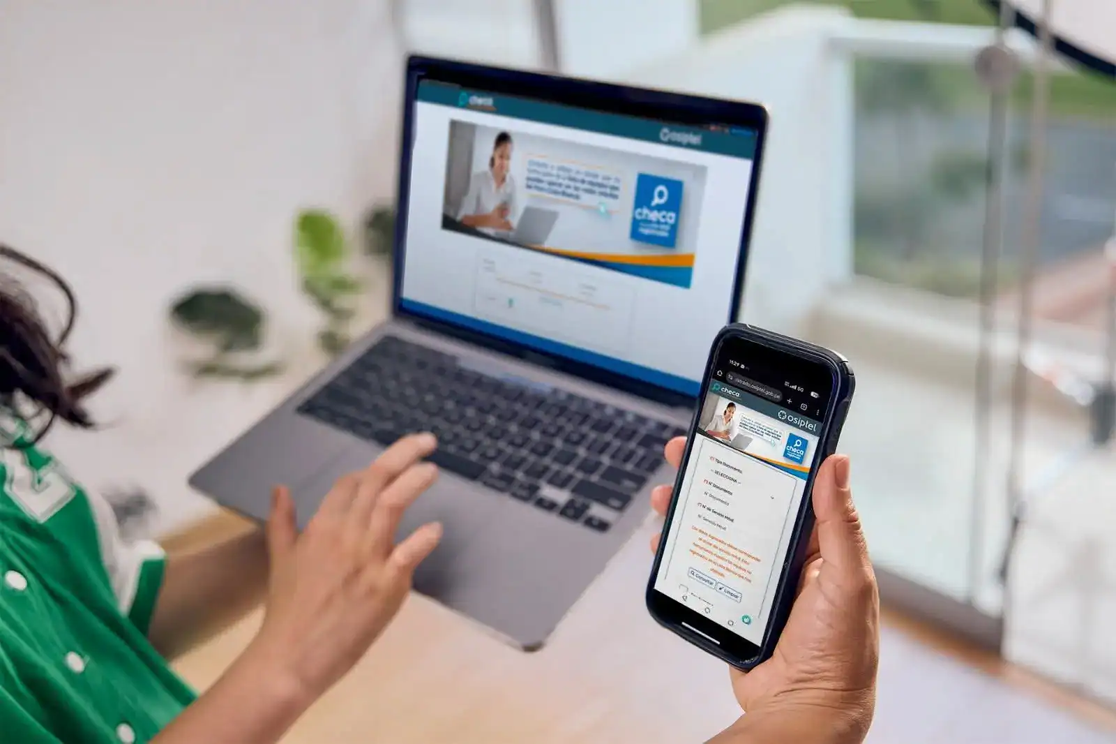 Acceso digital a Loreto Noticias mediante laptop y smartphone en una oficina moderna. Herramientas tecnológicas para mantenerse informado en tiempo real sobre noticias del Perú.
